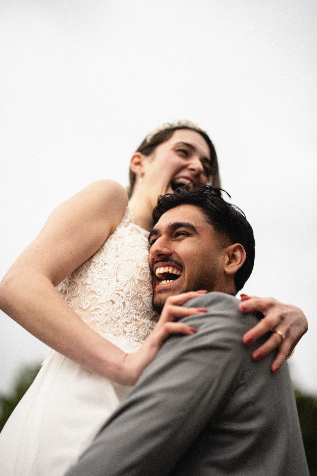 Bride and groom laughing in a joyful embrace