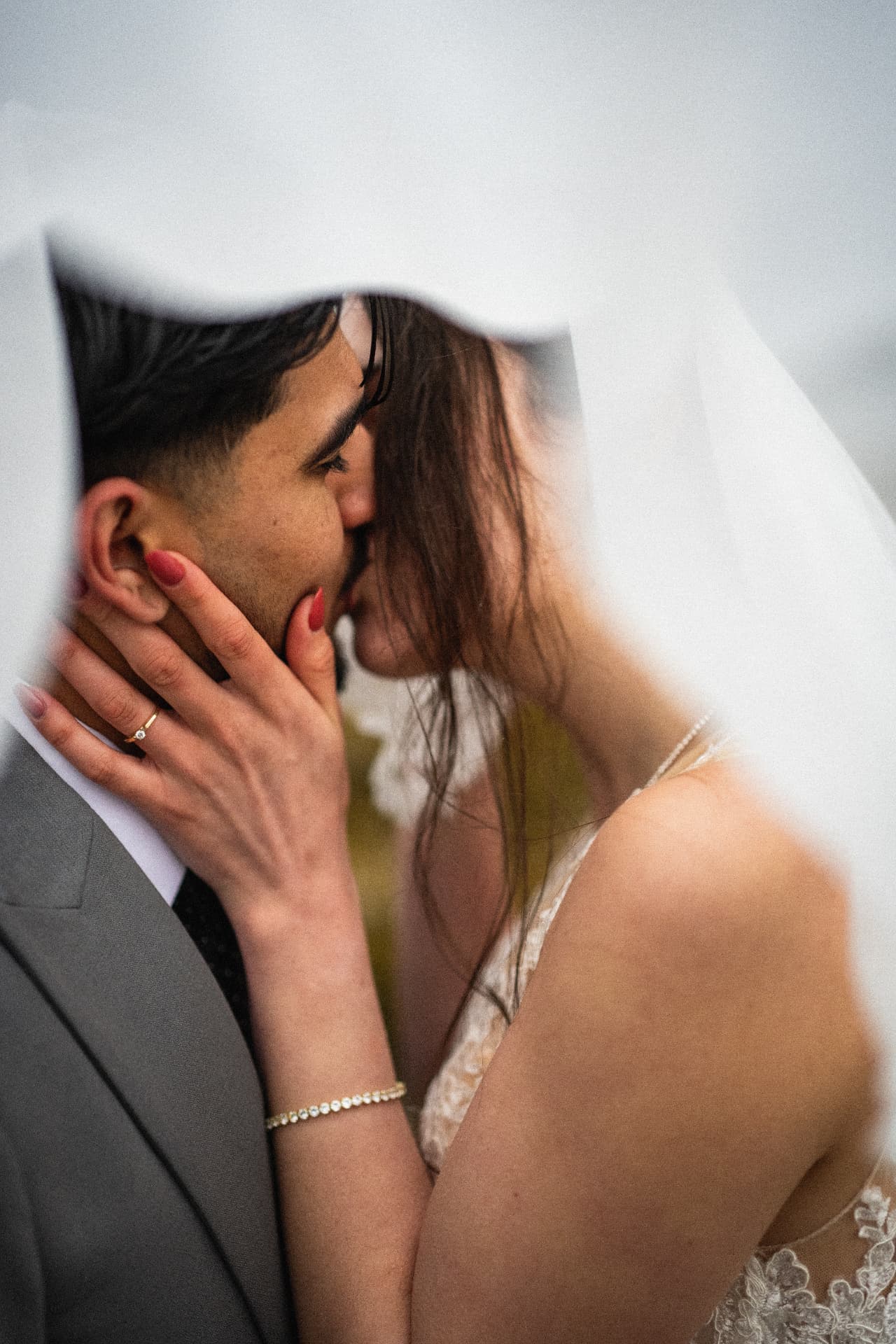 Couple kissing beneath the bride's veil